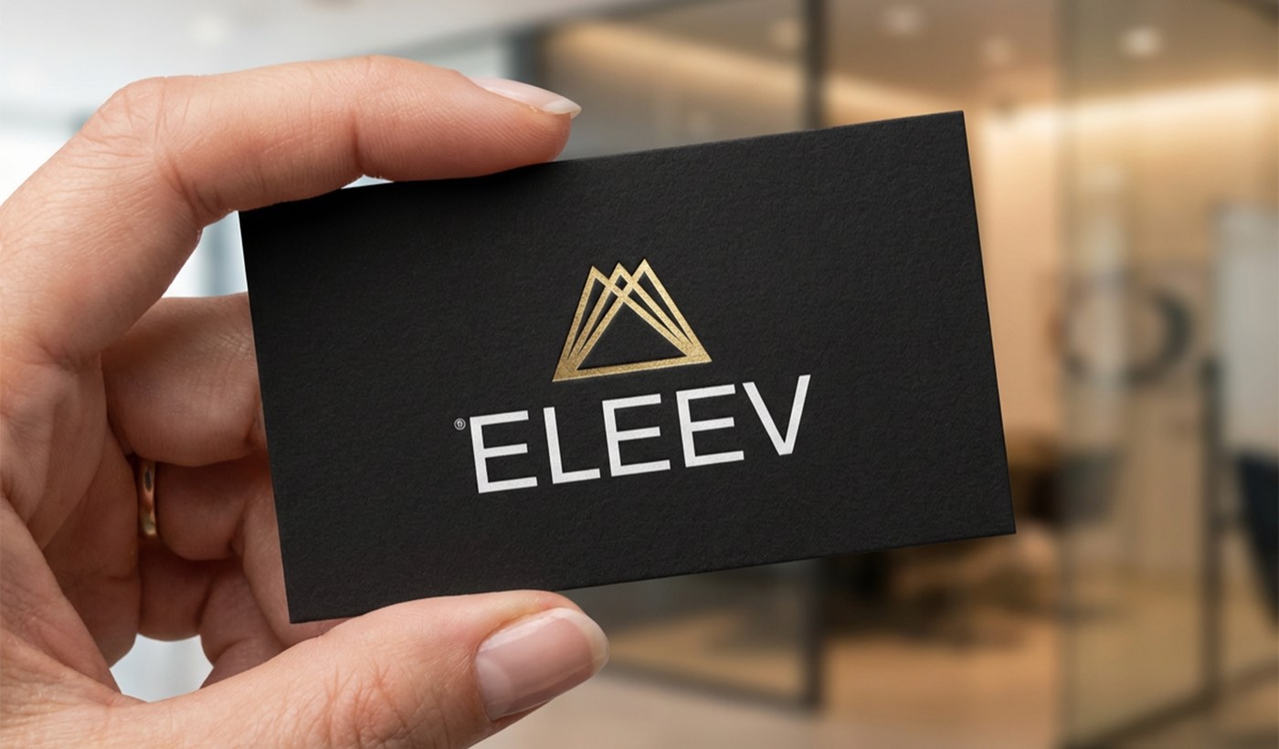 Biglietto da visita nero con il marchio Eleev in oro, tenuto in mano
